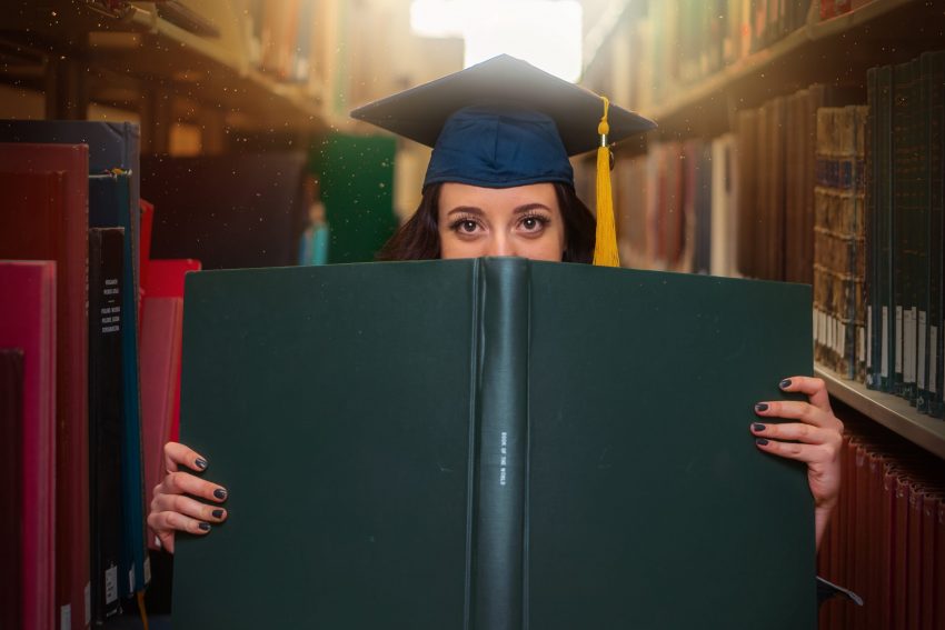 High‌ ‌school‌ ‌graduate‌ ‌in‌ ‌library‌ ‌with‌ ‌open‌ ‌book‌ ‌