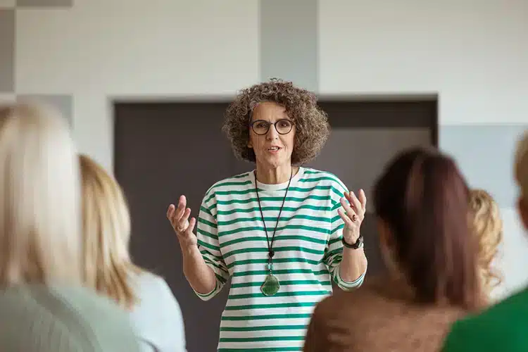 a senior business professor discussing business ethics with a class full of young college students