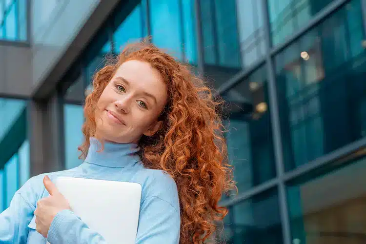 a female college student holding her laptop