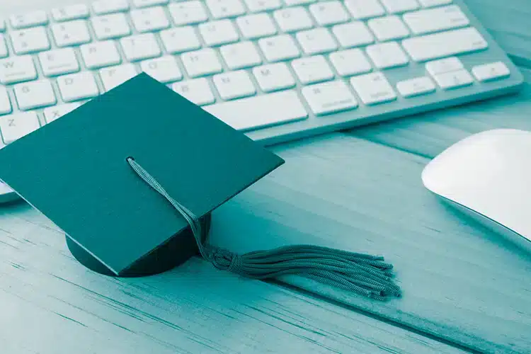 a graduation cap placed right next to a keyboard