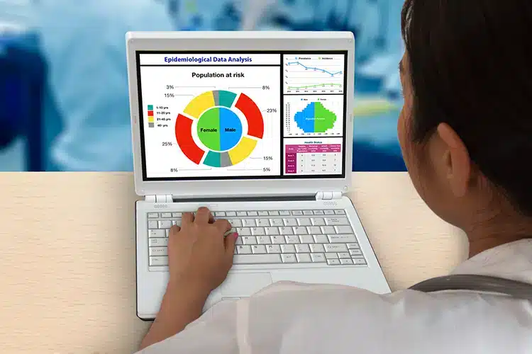 an epidemiologist assessing population disease stats on his computer