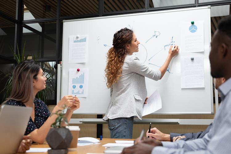 a female CEO explaining stats on a white board