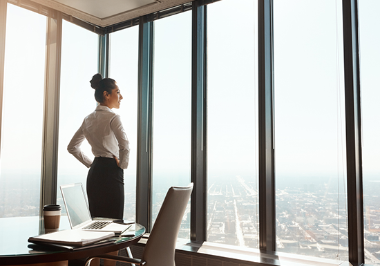 a female CEO looking out of her office windows
