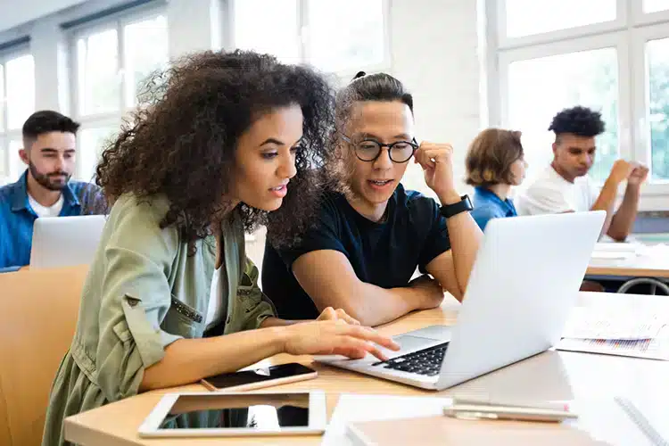 college students working together on a joint class project in their two-year degree program