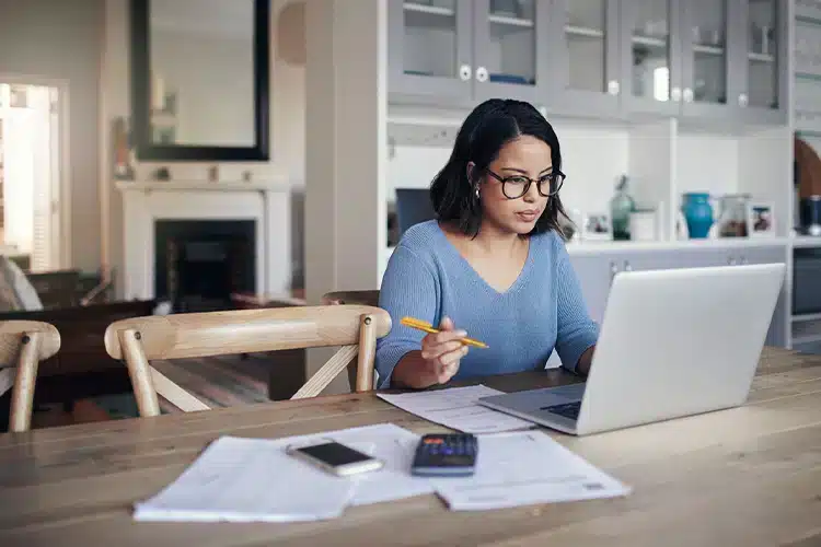 a female college student working on an assignment on her laptop