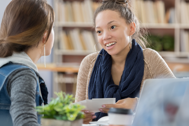 two female college students discussing paid internships