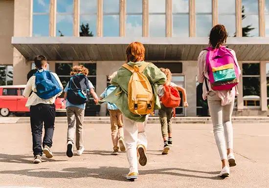 college students running toward the college building