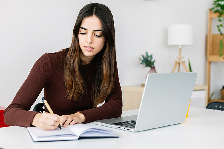 a female associate degree student working at her study desk