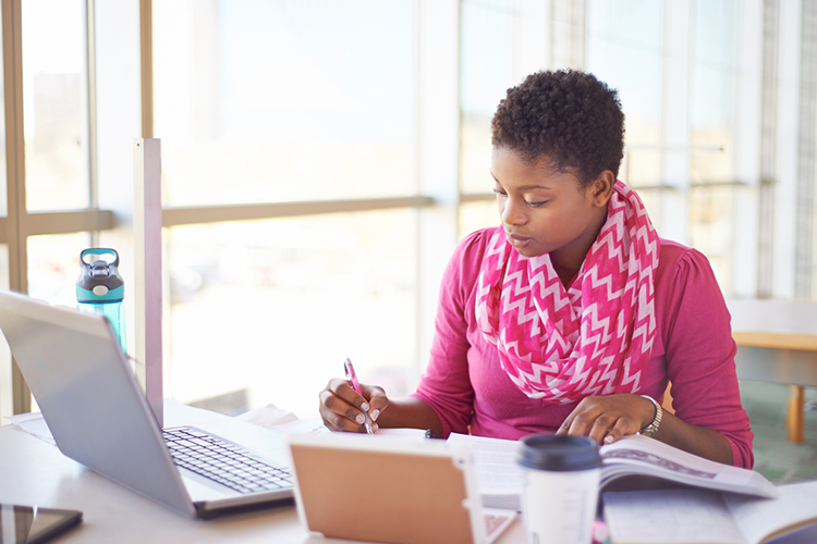 a female academic writer engrossed in her writing assignment