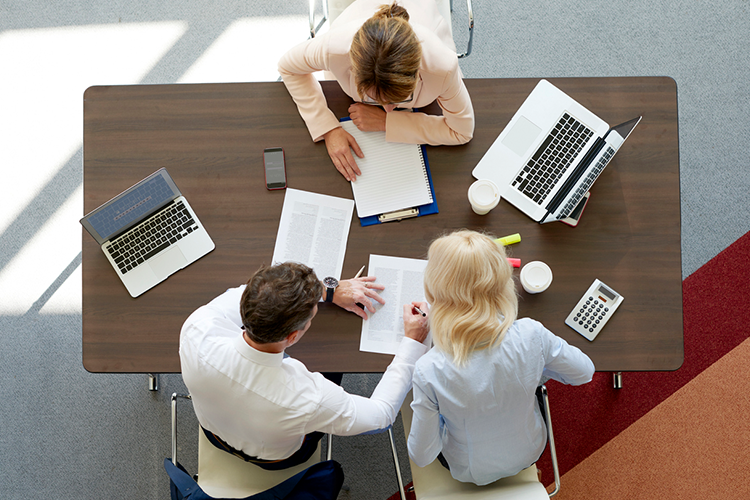 academic scholars seated at a desk, working together on a research paper