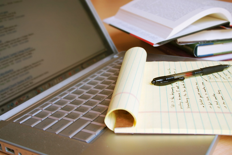 an online college student's computer and notebook kept on a study desk