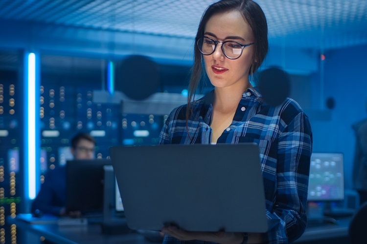 a female cybersecurity professional working on her laptop