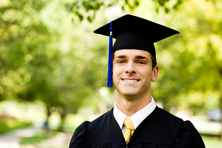 a male college graduate posing for a picture on the graduation day