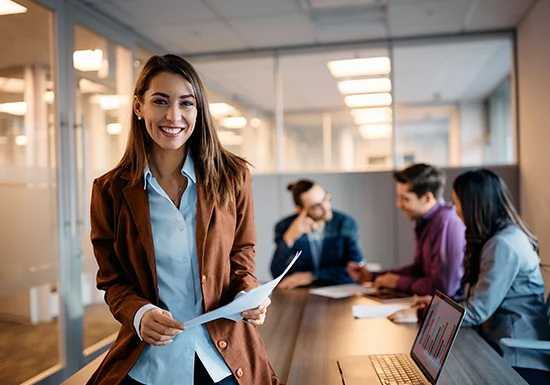 a female office manager posing in an office conference room